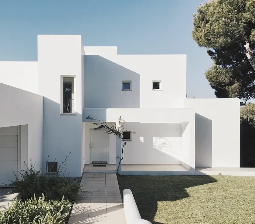 imagen de una casa vista desde fuera con un estilo moderno, minimalista, con muchas rectas y toda pintada de blanco